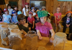 Dzieci przesypują ziarna w piekarni